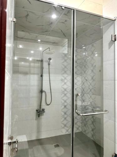 a shower with a glass door in a bathroom at Tinahouse -For Vietnamese guests only in Danang