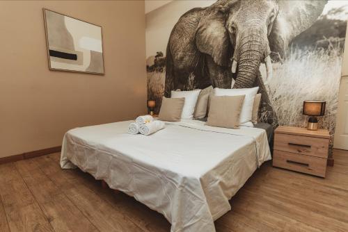 a bedroom with a large bed with an elephant on the wall at Maison Makoa et sa piscine proche du front de mer in Saint-Pierre