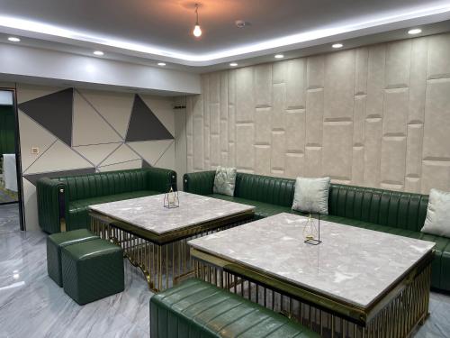 a green restaurant with two tables and green chairs at Numt Guren Resort in Ulaanbaatar