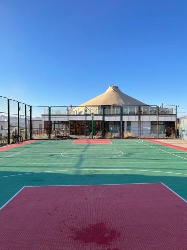 an empty tennis court with a building in the background at Numt Guren Resort in Ulaanbaatar