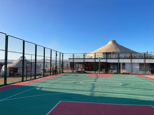 a tennis court in front of a building at Numt Guren Resort in Ulaanbaatar