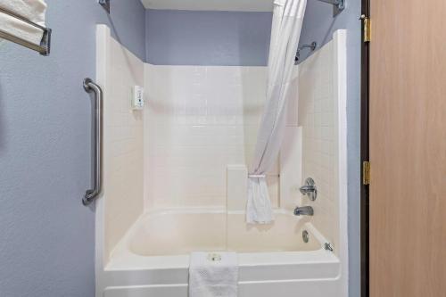 a white bath tub in a bathroom with a shower at Quality Inn & Suites Manhattan in Manhattan