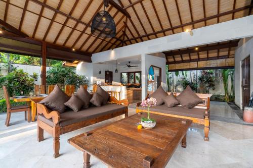 a living room with two couches and a table at Villa Alroda Antik - Peaceful 4BR Villa with Private Pool in Canggu in Dalung