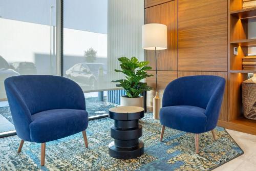 two blue chairs and a table in a room at Cambria Hotel Burbank Airport in Burbank
