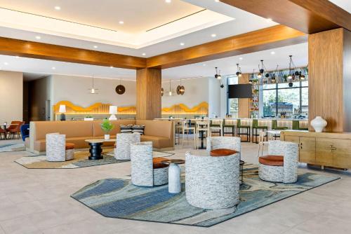 a lobby of a hotel with tables and chairs at Cambria Hotel Burbank Airport in Burbank