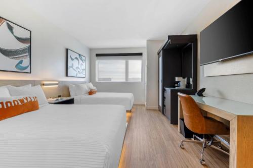 a hotel room with two beds and a desk at Cambria Hotel Burbank Airport in Burbank
