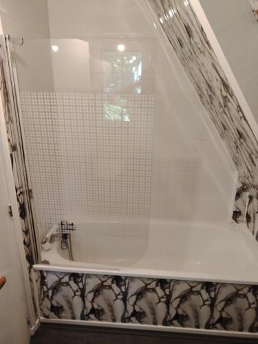 La salle de bains est pourvue d'une douche et d'une baignoire avec une porte en verre. dans l'établissement Chalet pleine nature 8mn de Vendôme, à Renay
