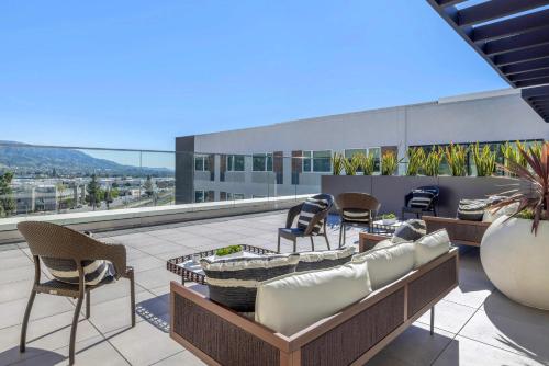 a patio with chairs and tables on a roof at Cambria Hotel Burbank Airport in Burbank