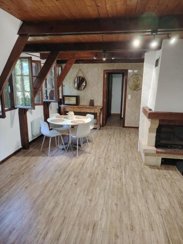 une pièce avec une table, des chaises et une cheminée dans l'établissement Chalet pleine nature 8mn de Vendôme, à Renay
