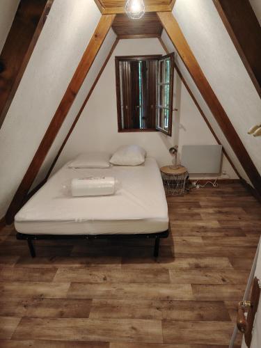 une chambre avec un lit dans un grenier dans l'établissement Chalet pleine nature 8mn de Vendôme, à Renay