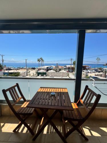 a wooden table and two chairs on a balcony at Dimitri Hotel in Himare