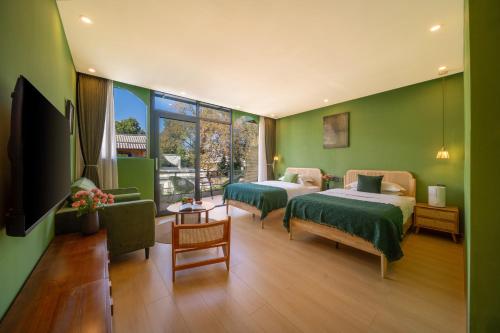 two beds in a room with green walls at Viewing Mount with Jun in Lijiang