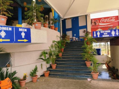a set of stairs with potted plants in a building at Hotel Nikunj, Kilerama in Ashta