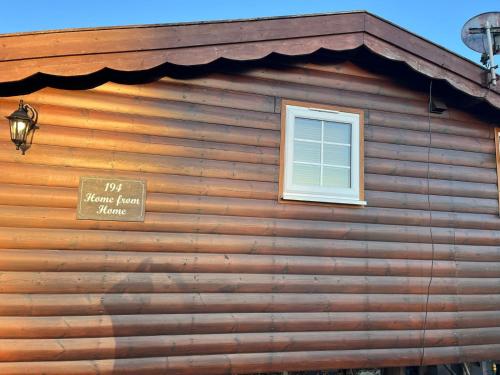 a sign on the side of a log house at Home From Home LogCabin in Trawsfynydd