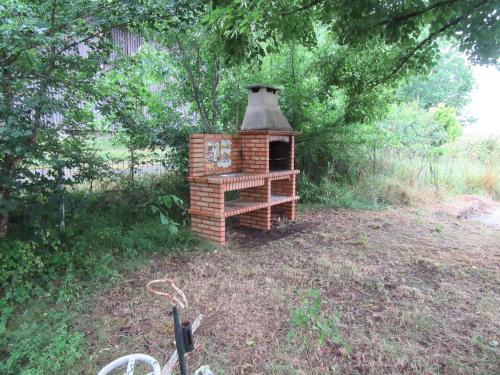 a small brick dog house sitting in a yard at La Bertrandie in Florimont-Gaumiers