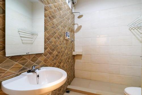 un baño con lavabo y espejo en Sans Hotel Grand Jitra Syariah Bengkulu, en Bengkulu