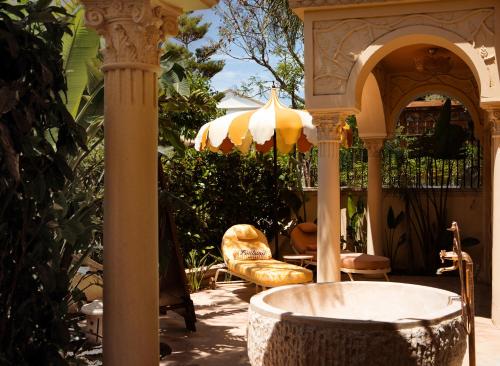 a patio with an umbrella and a chair and a tub at Casa Fontana in Alacati