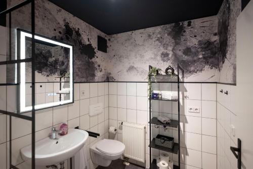 Un baño blanco con lavabo e inodoro. en Black & White Apartment - Balkon, Netflix, Nespresso, Zentral, Messe, en Chemnitz