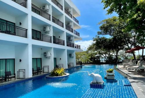 an exterior view of a hotel with a swimming pool at Cosy Beach Hotel - SHA Extra Plus in Pattaya South