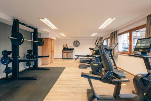 a gym with several treadmills and exercise bikes at Hotel Brugger in Fulpmes