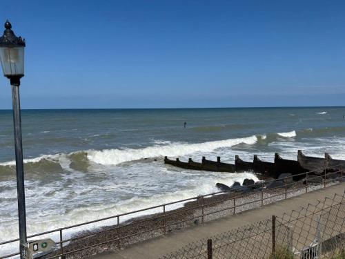 a beach with a bunch of boats in the water at Seafront Sheringham 1 bed Apt sleeps 4 - 1xdog in Sheringham