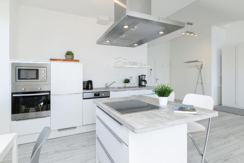 - une cuisine blanche avec des appareils électroménagers blancs et une table dans l'établissement Strandweg 6-7 Sandhalm, à Möltenort