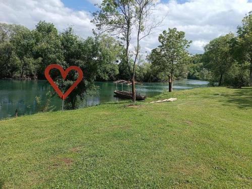 a heart sign in the grass next to a river at Una Meryland in Kulen Vakuf