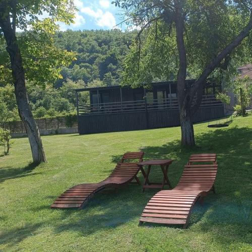 two benches and a picnic table in a park at Una Meryland in Kulen Vakuf