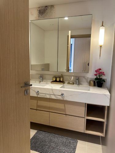 a bathroom with a sink and a large mirror at ROYAL APARTMENTS DUBAI in Dubai