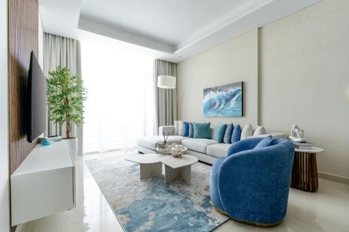 ラス・アル・ハイマにあるNasma Luxury Stays - Calming Blues Stylish 1BR in Hayat Islandの青いソファとテーブルのあるリビングルーム