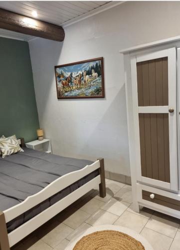 a bedroom with a bed and a painting on the wall at Les Antiers in Saint-Georges-dʼElle