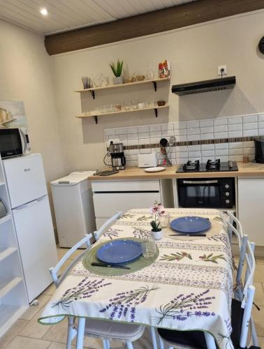 d'une cuisine avec une table et des plaques bleues. dans l'établissement Les Antiers, à Saint-Georges-dʼElle