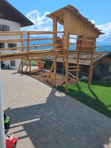 a wooden pergola sitting on top of a patio at Schweiggerhof -Agriturismo- Farm Holidays in Villandro