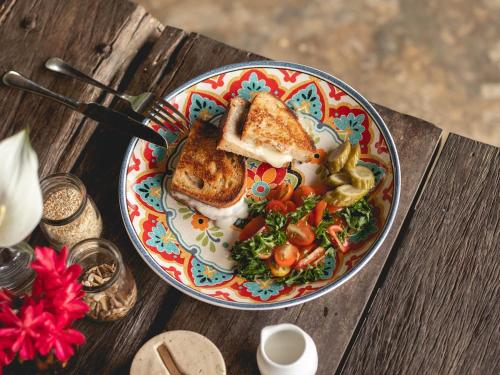 einen Teller mit Brot und Gemüse auf dem Tisch in der Unterkunft Coconut Corner - Rice Field Dome in Tanah Lot