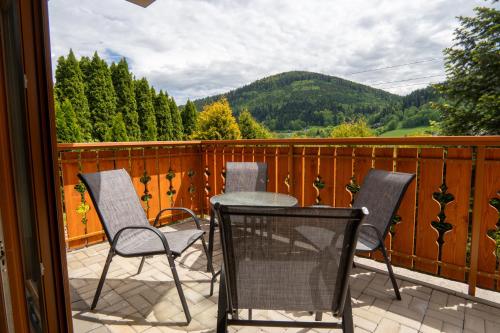 a patio with three chairs and a table on a balcony at Willa i Wzgórze Jerrego Apartamenty, Domki i Pokoje z Widokiem na Góry in Szczyrk