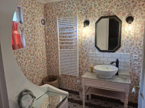 une salle de bain avec un lavabo et un miroir dans l'établissement La petite maison normande, à Honfleur