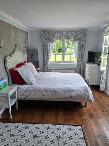une chambre avec un grand lit et une fenêtre dans l'établissement La petite maison normande, à Honfleur