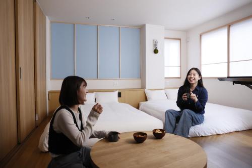 福岡市にある博多の旅籠 すノやの二人の女性が部屋のテーブルの周りに座っている