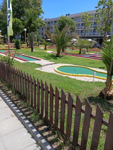 een houten hek in een park met een speeltuin bij Apartment Orhideya in Sunny Beach