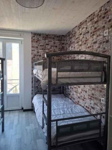 - une chambre avec 2 lits superposés dans un mur en briques dans l'établissement le nid des choups esprit cocoon 2 chambres, à La Bourboule