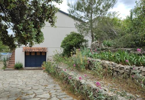 un jardin en face d'une maison avec garage dans l'établissement chambre privée dans maison en garrigue, à Nîmes