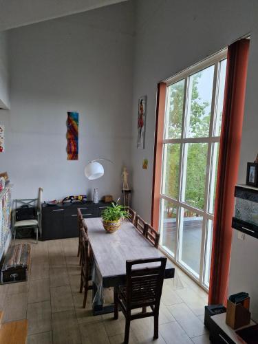 un salon avec une table et une grande fenêtre dans l'établissement Notre petit coin de paradis, à Saint-Germain-du-Bel-Air