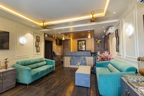 a living room with blue couches and a kitchen at Chandrika Green Resort in Vrindāvan