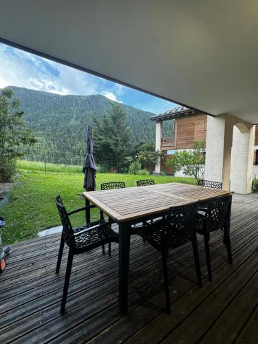 une table en bois et deux chaises sur une terrasse dans l'établissement Bien-être, à Séez