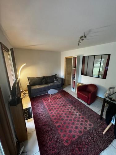 un salon avec un canapé et un tapis rouge dans l'établissement Bien-être, à Séez