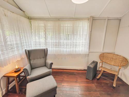 a living room with a chair and a table and a television at West Avenue Hideaway in Wynnum - 1 Bed and 1 Bath in Brisbane