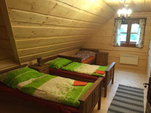 a room with two beds in a log cabin at Drevenica Vanesa in Terchová
