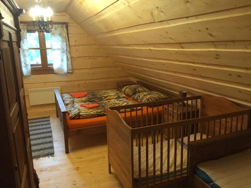 Cabaña de madera con cama en una habitación en Drevenica Vanesa en Terchová