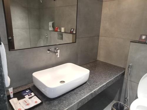 a bathroom with a white sink and a mirror at Zip By Spree Hotels Chinchwad in Chinchiwad