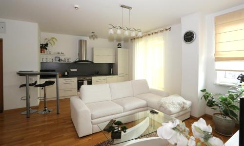 a living room with a white couch and a table at Apartamentai Panevezys in Panevėžys